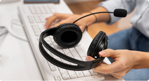 Woman holding pair of headphones